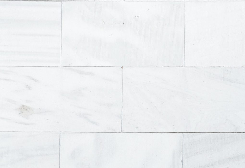 Modernios pilko atspalvio akmens masės plytelės paklotos šviesioje svetainėje.