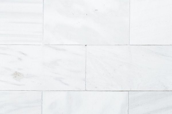 Modernios pilko atspalvio akmens masės plytelės paklotos šviesioje svetainėje.